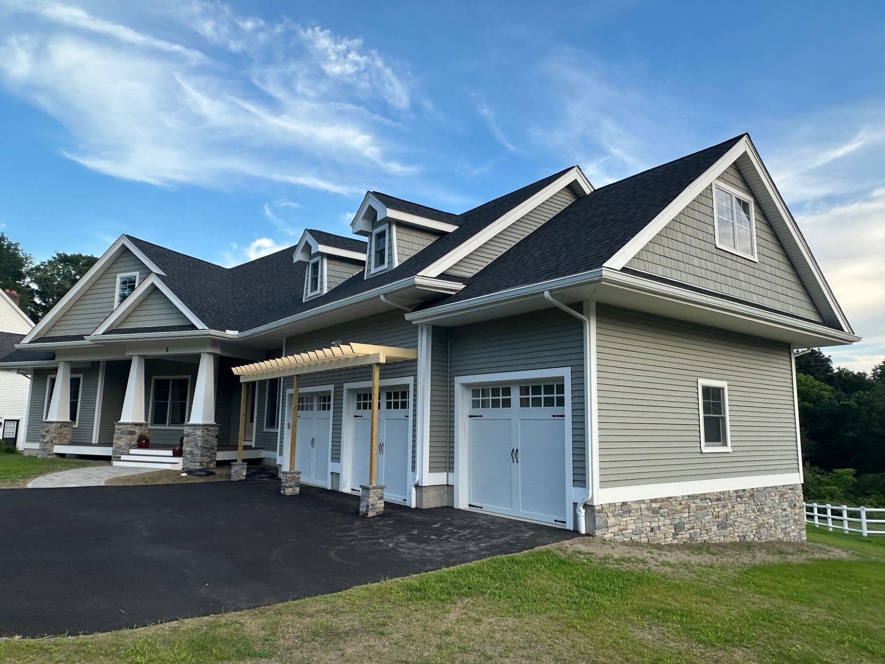 Craftsman home in Grafton, MA with light gray lap siding, white trim and a triple garage
